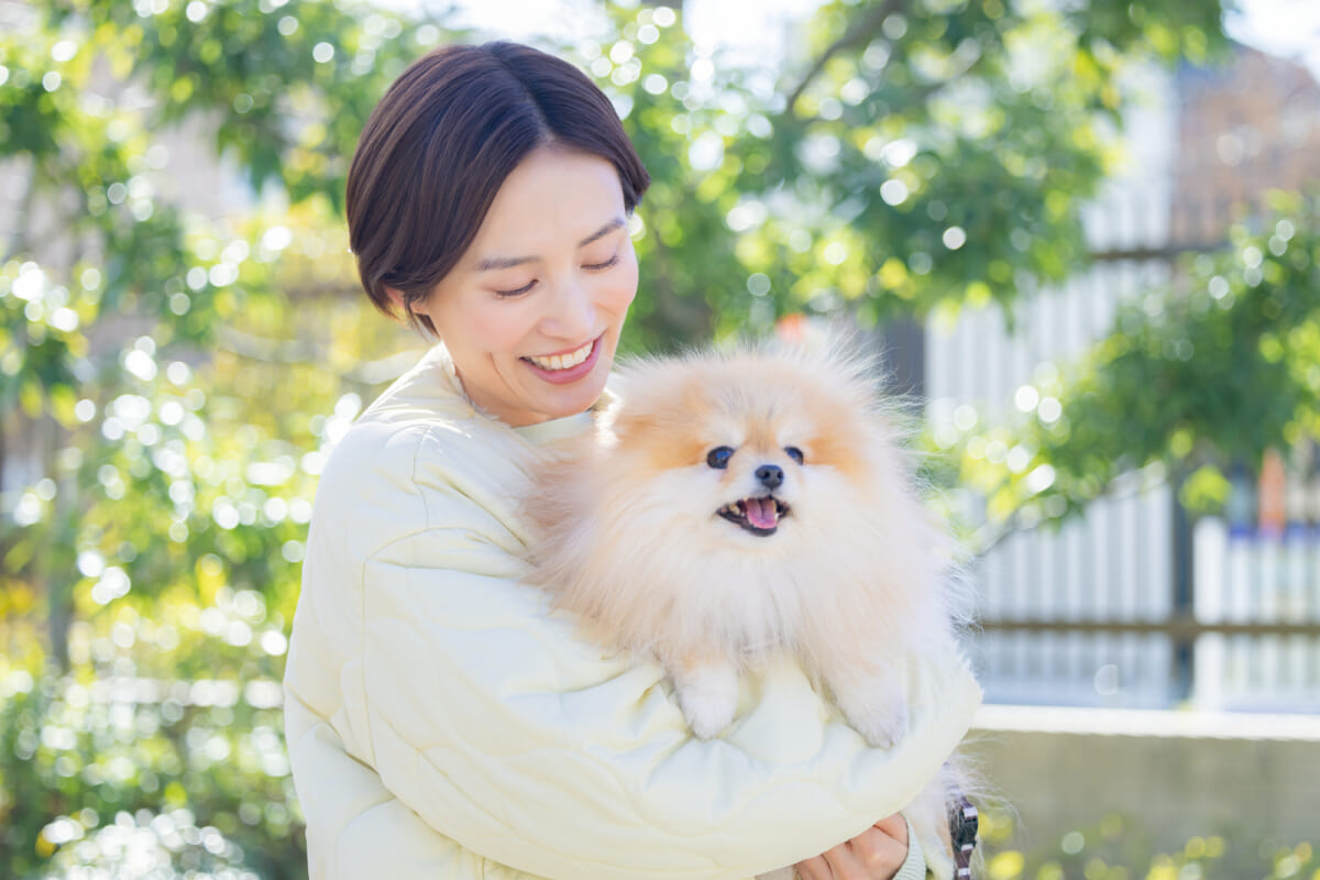 ペットの犬を抱きかかえる女性